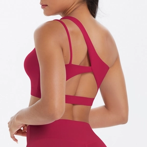 Detail of dark pink sports bra featuring asymmetric multi-strap back design and cross pattern