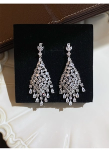 Macro detail of silver zircon tassel drop earrings featuring sparkling diamond patterns