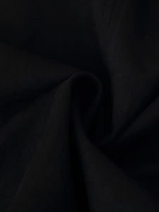 Texture macro détaillée du tissu ethnique noir avec un drapé souple et une finition mate