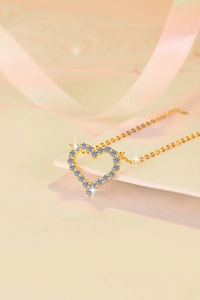 Détail du pendentif en forme de cœur avec diamants pavés sur fine chaîne dorée