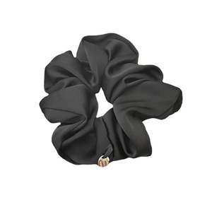 Premium black satin scrunchie with a gold metal charm and elegant pleated silk texture