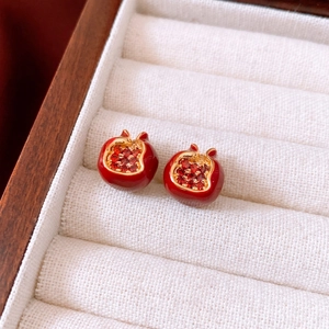 Detailed macro shot of vintage pomegranate earrings with red crystals and 18K gold plating