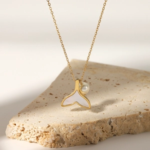 Mermaid tail gold necklace with natural mother of pearl and pearl pendant on a stone