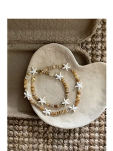 Detail of beaded shell necklace with white starfish charm and metal lobster clasp