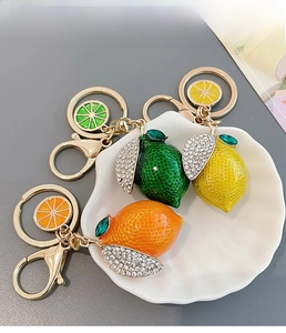 Close-up of crystal lemon and orange keychains with rhinestone embellishments
