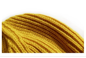 Close-up of ginger yellow knit beanie showing detailed thick wool yarn texture