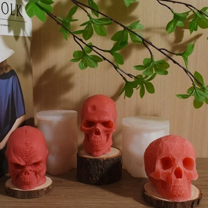 Three red Halloween skull candles featuring stitched details and their silicone molds