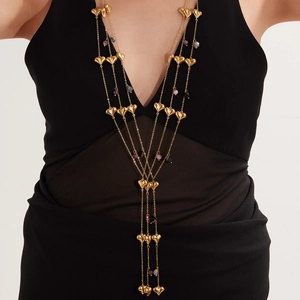 Layered gold heart necklace with blue agate beads shown on a black deep V dress