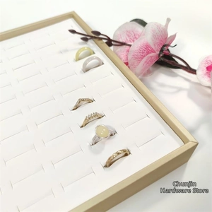 Detail view of various rings and faux gemstones in a 100-slot white display organizer tray