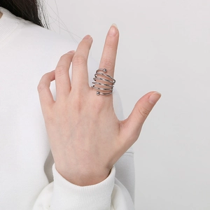 Detail shot of multi-layer spiral silver ring shown on hand with minimalist metal coil design