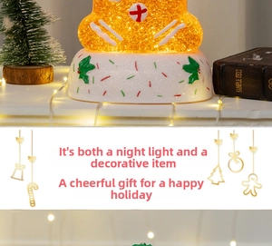Close-up of a gingerbread man snow globe night light with warm LED lighting and gold sequins