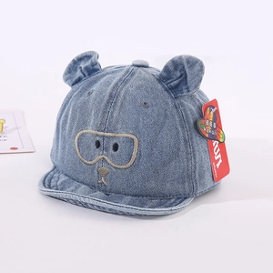 Détail de la casquette bébé en jean avec oreilles d'ours 3D et broderie de dessin animé