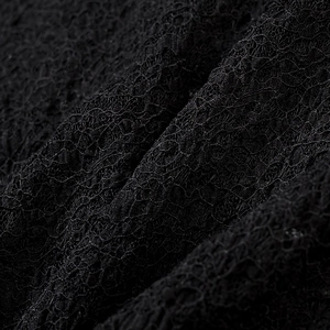 Gros plan sur la dentelle florale noire avec une texture détaillée sur la jupe longue