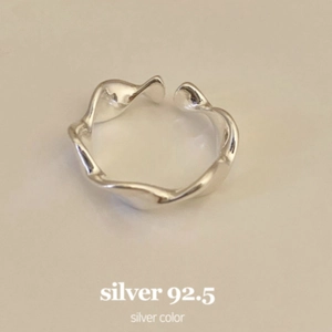 Macro shot of polished 925 sterling silver ring featuring a minimalist wavy design detail