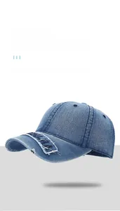 Dettaglio del cappello da baseball in denim blu lavato con bordi consumati e ricami