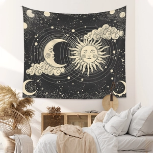 Bohemian sun and moon tapestry hanging above a bed with minimalist celestial star patterns