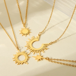 Detailed close-up of four gold stainless steel necklaces with sun and star pendants