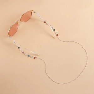Detail of colorful enamel heart eyewear chain with sparkling rhinestones on warm background