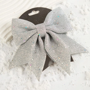 Dettaglio del fiocco decorativo argento glitterato con cartoncino su sfondo innevato
