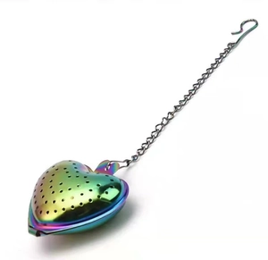 Macro-detail van regenboog roestvrijstalen hartvormige theezeef met metalen ketting