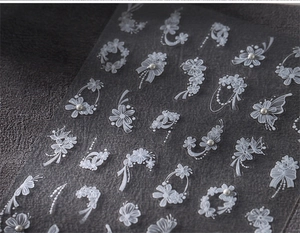 Gros plan de stickers à ongles fleurs blanches avec dentelle et détails de perles