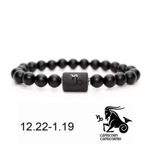 Detailed macro view of Capricorn matte black beaded bracelet with gold spacers and zodiac charm