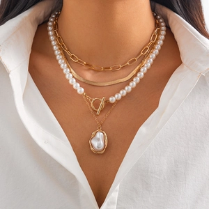 Baroque irregular pearl layered necklace with gold disk pendant and snake chain on model