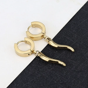 Detailed view of polished golden horn pendants on titanium steel hinged hoop earrings