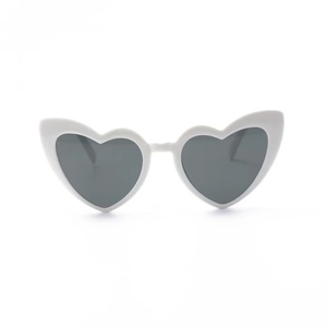 Detail shot of heart-shaped white sunglasses featuring dark grey lenses and a glossy finish