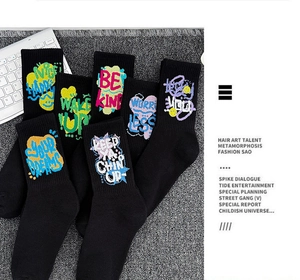 Close-up of black cotton crew socks featuring colorful artistic graffiti text and streetwear patterns