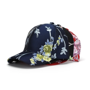 Detail of three cotton baseball caps with vibrant floral embroidery in multiple colors