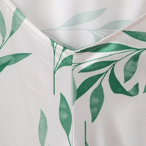 Robe licou en soie avec col en V et imprimé feuilles vertes sur satin blanc crème