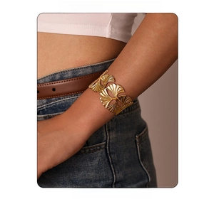 Detailed view of a gold ginkgo leaf cuff bracelet worn on wrist for a stylish look
