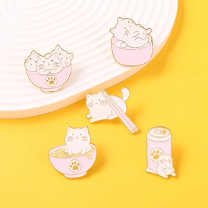 Vue détaillée de cinq pins en émail de chats roses et blancs sur un support de présentation