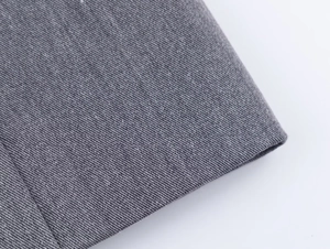 Détail de la texture du tissu en sergé gris et coutures fines sur un ensemble tailleur