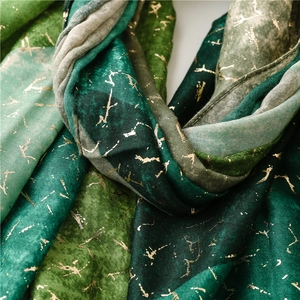 Detailed close-up of soft green cotton scarf featuring gold foil splatter patterns
