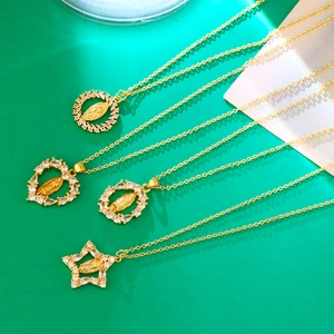 Detail view of four gold Virgin Mary pendants with sparkling heart and star zircon frames