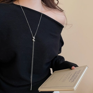 Detail of silver Y-shaped lariat necklace with pavé crystal slide on black clothing