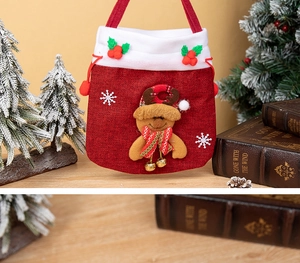 Detail of red Christmas drawstring gift bag with 3D gingerbread man and golden bells