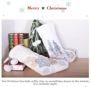 Close-up of white plush Christmas stocking with blue and gold snowflake embroidery