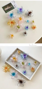 Detailed view of colorful gradient plumeria resin hair claws in various sizes and shades
