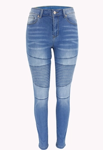 Detail of blue skinny jeans featuring biker-style ribbed pleats on the thighs and knees