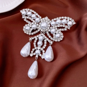 Detail of silver butterfly brooch with rhinestones and hanging teardrop pearls