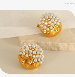 Detail shot of heart-shaped earrings with white pearls and gold lava-textured metal