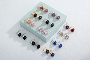 Macro shot of colorful faceted square crystal earrings with golden and silver hooks