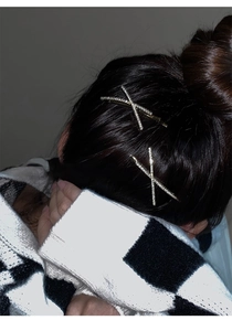Detail shot of criss-cross hair clips with sparkling rhinestones and gold metal finish