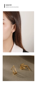 Detail of gold-plated double-row C-shaped hoop earrings with sparkling white zircons