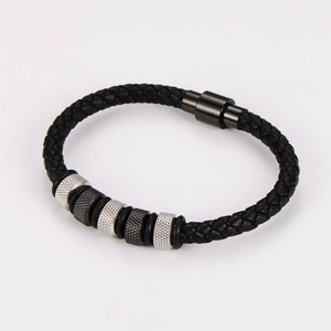 Close-up of black braided leather bracelet with silver magnetic clasp and metal beads