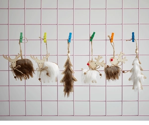 Detail of wool and wood reindeer and tree ornaments hanging on a pink grid rack
