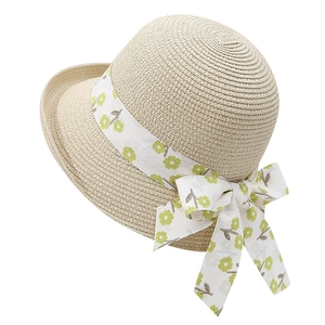 Détail d'un chapeau de paille beige avec ruban en dentelle florale et texture tissée